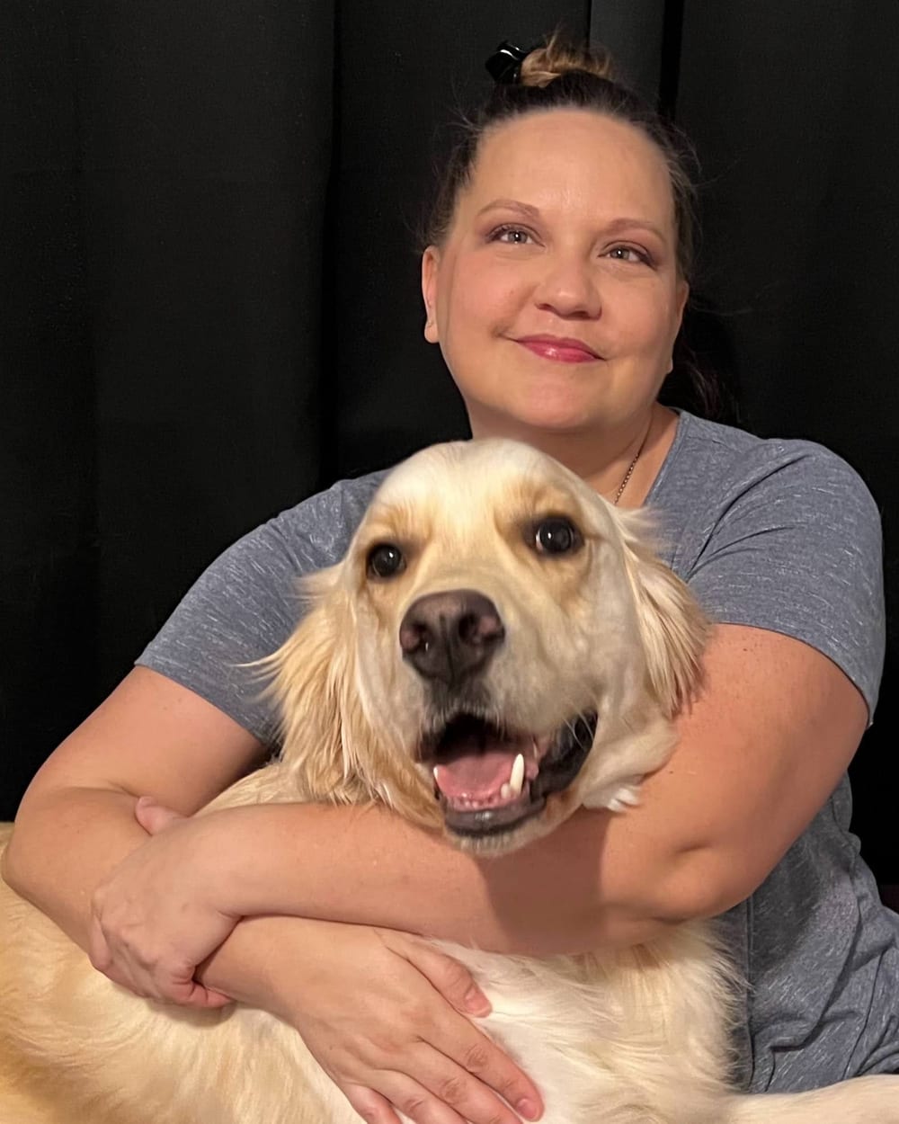 Emily Ward smiling with her golden retriever